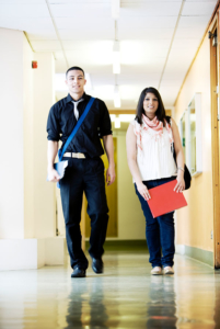 Young man and woman walking together in a school hallway